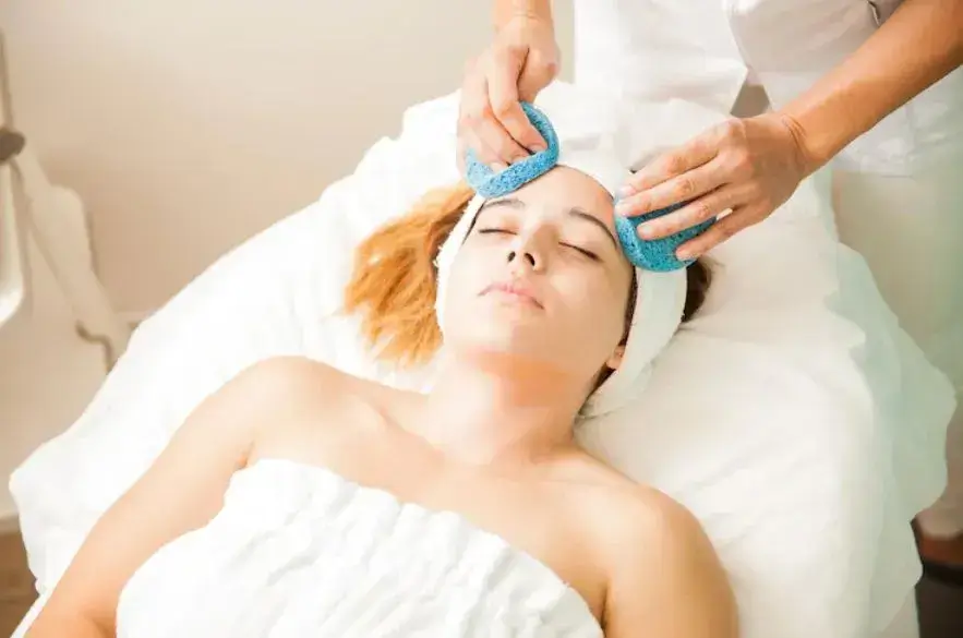 Portrait of a beautifu young brunette relaxing during a moisturizing face treatment and having Cranial Facia Therapy at a spa