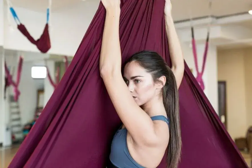 Woman hanging on aerial yoga