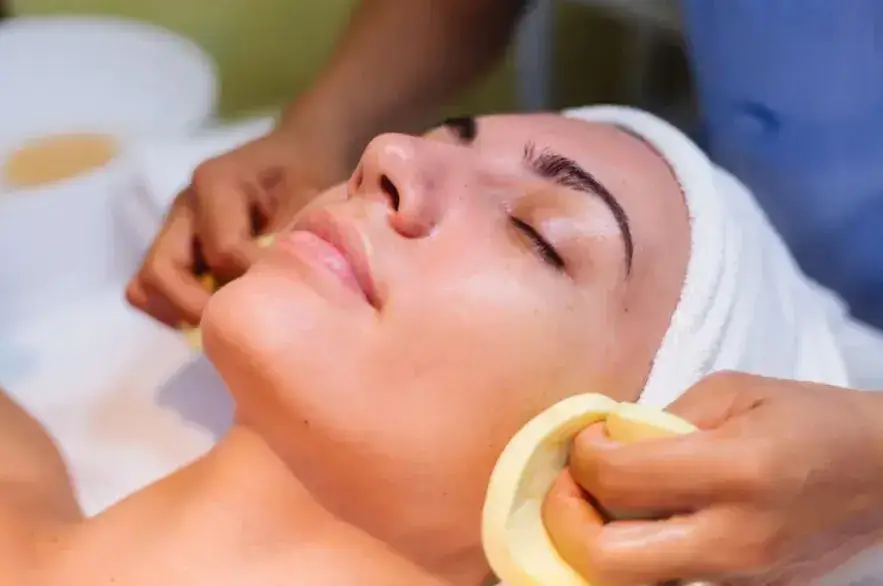 Young woman lying on cosmetologist s table during rejuvenation procedure