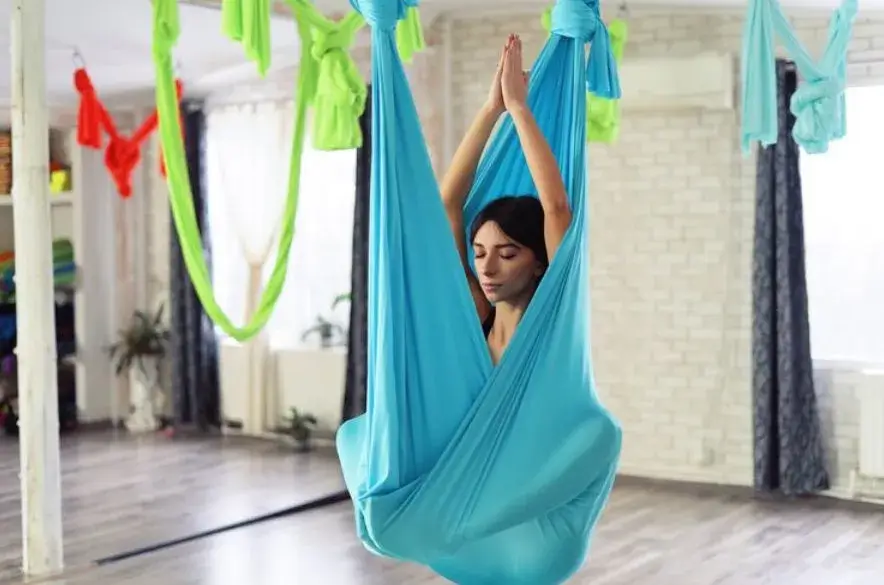 adult woman practices Aerial Yoga